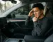 editorial magazine photography, handsome Asian man sitting in a Tesla Model Y interior looking at the center console wit