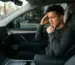 editorial magazine photography, handsome Asian man sitting in a Tesla Model Y interior looking at the center console wit